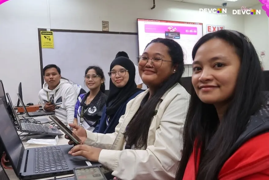 Hackathon participants at their laptops with a 3-hour countdown on the screen behind them