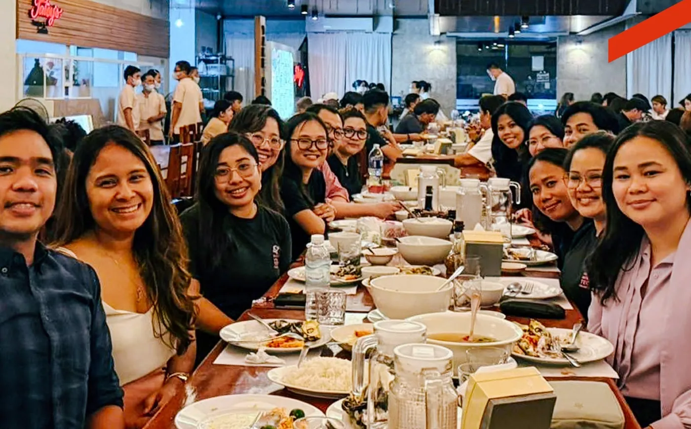 Organizers and regional tech leaders smiling at a long community dinner table