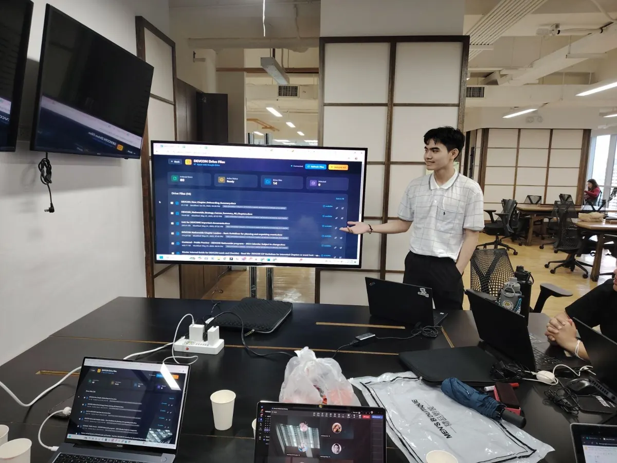 An intern presenting an AI tool that searches DEVCON documents on a big screen