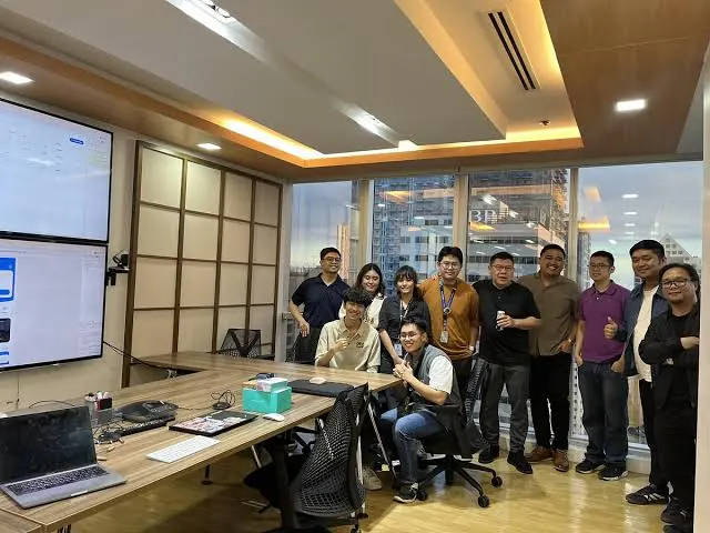 A large group of interns and mentors smiling in a boardroom